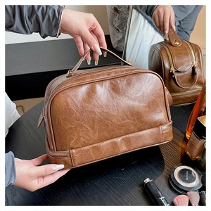 Macro shot of brown retro makeup bag with double zippers and soft PU leather texture