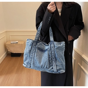 Detail of vintage washed denim tote bag showing its large capacity and front pocket