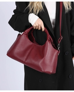Close-up of wine red litchi texture handbag with braided handles and adjustable strap
