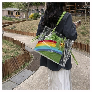 Detailed shot of transparent PVC beach bag with green canvas pouch and rainbow motif