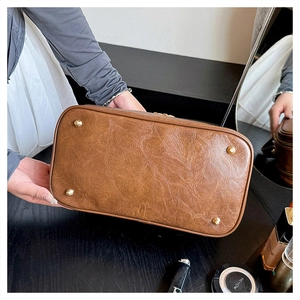 Detail of vintage brown textured leather base with four golden protective metal studs