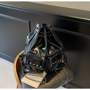 Detail of black waterproof bucket bag with silver studs and leather chain straps