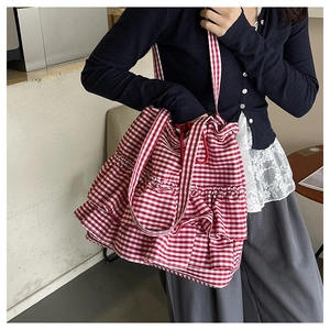 Detailed view of red and white gingham tote bag with layered ruffle design on the shoulder