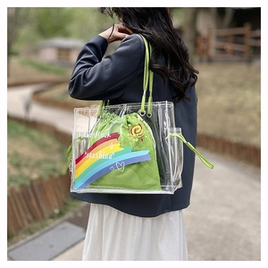 Detail of transparent PVC beach bag with green cotton drawstring pouch and rainbow print