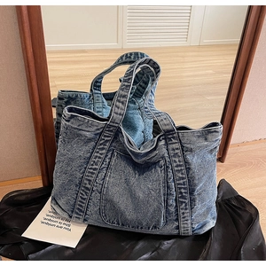 Detailed view showing the vintage wash texture of the large capacity denim tote bag