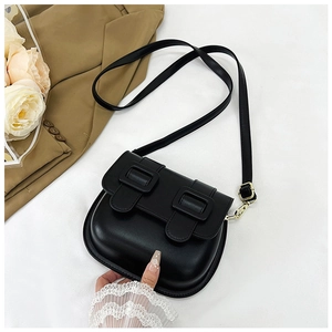 Détail d'un sac besace noir vintage avec doubles boucles et accents métalliques dorés