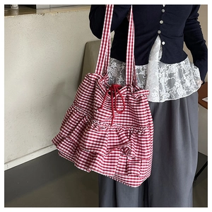 Detail of red and white checkered tote bag with elegant double layer ruffle hem and drawstring