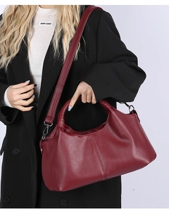 Detail view of burgundy leather tote bag with vintage texture and metallic hardware