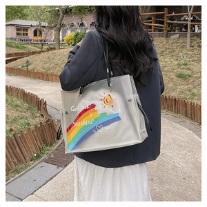 Detail view of large PVC beach bag with rainbow print and durable black handle strap