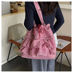 Detail of red and white gingham tote bag with layered ruffles and drawstring closure