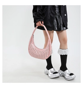 Detailaufnahme einer pinken Hobo-Tasche mit silbernen Nieten im modischen Y2K-Stil
