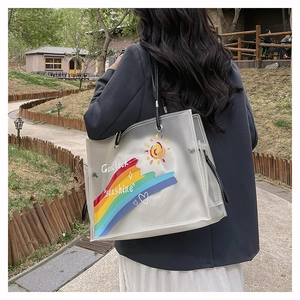 Detail of transparent PVC tote bag with colorful rainbow graffiti and black leather straps