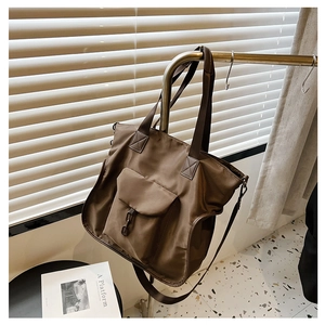 Detailed view of brown waterproof nylon tote bag with functional utility front pocket