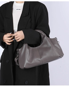Detailed view of the large capacity shoulder bag with a woven handle in mocha grey leather