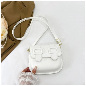 Détail du sac de selle vintage blanc avec boucles dorées et bandoulière réglable