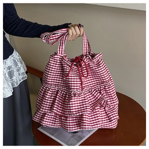 Detail view of red gingham tote bag featuring triple ruffles and drawstring closure