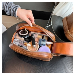 Macro shot of large capacity brown PU leather toiletry bag with golden zipper detail