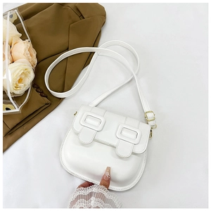 Détail du sac selle blanc minimaliste avec doubles boucles et texture cuir délicate