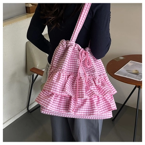 Detail of pink plaid canvas tote bag with triple-layer ruffles and drawstring closure