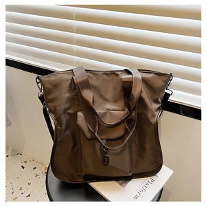Detail of water-resistant nylon tote bag with metal hook and reinforced handles