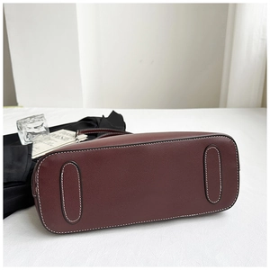 Close-up of the reinforced dark red leather bag base with detailed white stitching