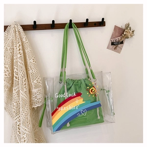 Detail view of transparent PVC beach bag with green drawstring pouch and rainbow prints