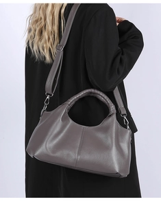 Detail of grey leather handbag showing woven handle and silver metal strap hooks