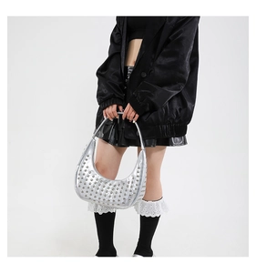 Detail der silbernen Halbmond-Nietentasche mit Metallic-Leder und Nieten im Punk-Stil