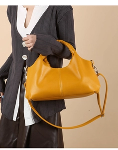Close-up of bright yellow tote featuring woven handle detail and pebble texture leather