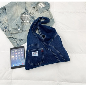 Close-up of vintage denim tote bag with cat badge and functional front pocket