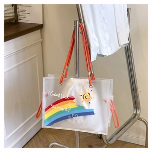 Detail of transparent PVC beach bag with orange handles and lucky sunshine print