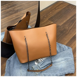 Detail of vintage caramel tote bag showing leather texture and metal chain strap