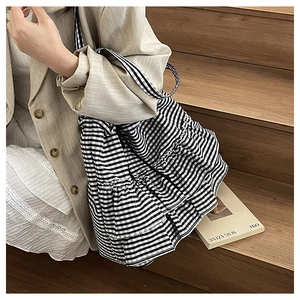 Detail of checkered canvas tote bag with multi-layer ruffles and fabric handles