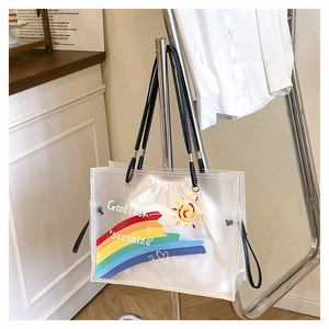 Detail of transparent PVC beach bag with rainbow drawstring canvas pouch and black handles