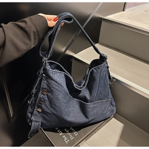 Detailed view of dark blue denim tote bag with metal studs on street style stairs