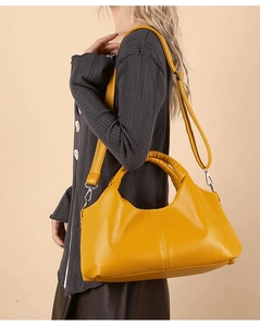 Close-up of yellow lychee pattern leather handbag with pleated handle and silver hardware