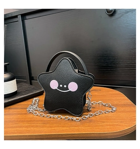 Detail of star-shaped black lychee leather mini bag with chain strap and smile face