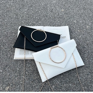 Gros plan de pochettes minimalistes noir et blanc avec poignées en anneau doré
