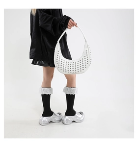 Detailansicht einer weißen Halbmond-Schultertasche mit silbernen Punk-Metallnieten