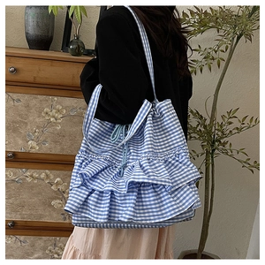 Detail view of large canvas tote bag with blue gingham pattern and layered ruffle design