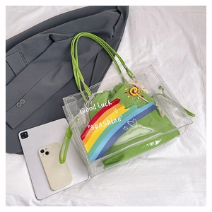 Detail of transparent PVC tote bag with green Good Luck inner pouch and shoulder strap