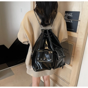 Detail of waterproof black bucket bag with silver studs and chain strap on a model