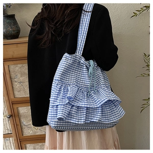Close-up of blue gingham canvas tote bag with double ruffle layers and drawstring closure