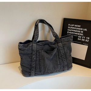 Detail of grey washed denim tote bag showing fabric texture and front pocket