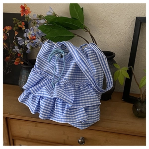 Close-up of blue gingham canvas tote bag featuring layered ruffles and drawstring detail