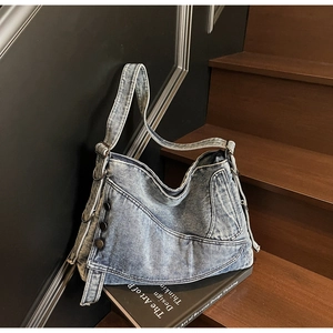 Detail of vintage washed blue denim tote showing metal buttons and rustic stitching