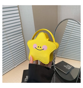 Close-up of yellow star-shaped mini handbag featuring a cute smiley face and silver chain