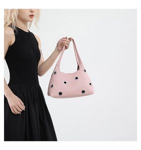 Detail of pink rivet shoulder bag with silver eyelets and textured lychee pattern leather