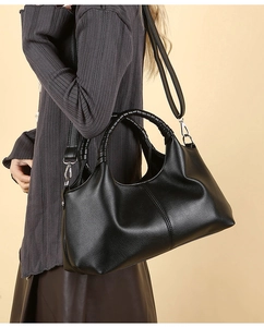 Fashionable black pebbled leather tote bag with unique woven handle detail and silver strap