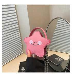 Close-up of pink star-shaped leather crossbody bag with cartoon smiley face and chain